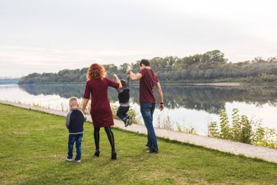 Parenthood, childhood, people concept - family walking...