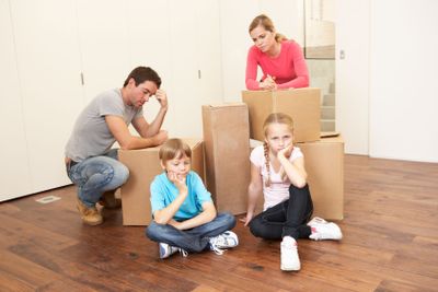 Young family looking upset among boxes