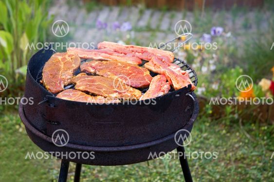 Summer grilling in garden. Fresh meat on grill