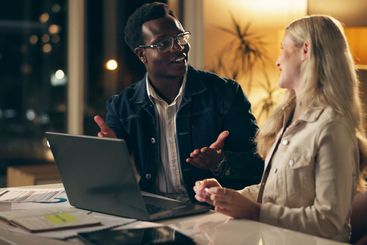 Laptop, teamwork and business people together at night...