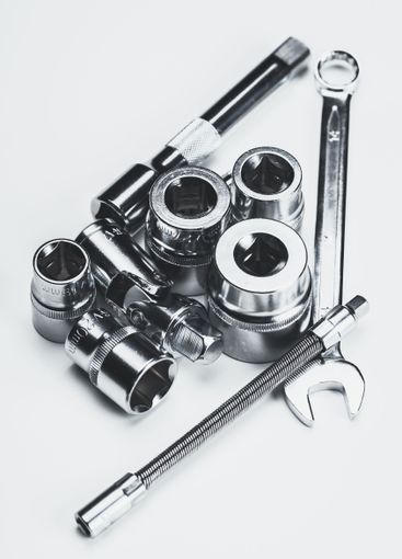 Collection of metallic hand tools arranged on a smooth...