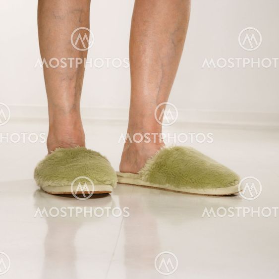 Feet wearing slippers.