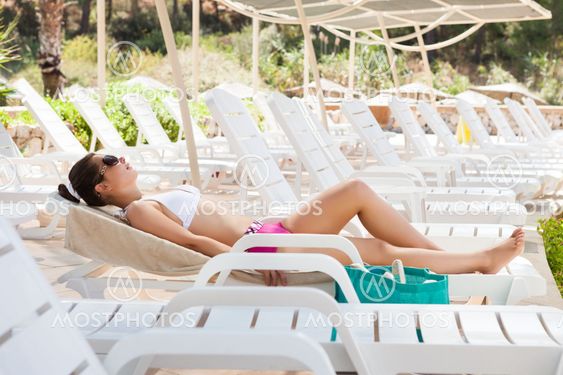 Woman In Swimwear Sunbathing On Lounge Chair