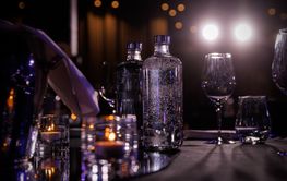 The glass water bottle on the restaurant table