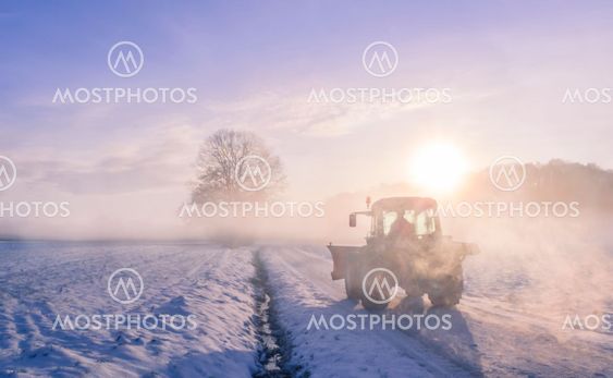 Tractor silhouette on snowy field