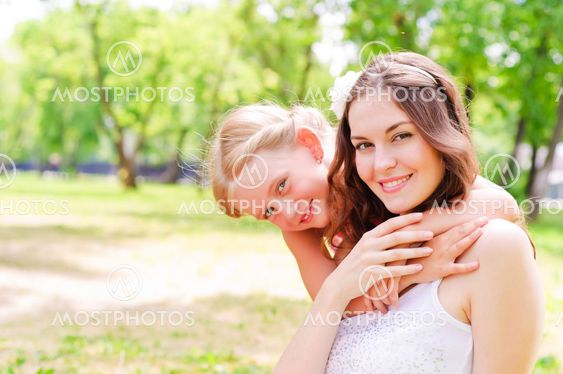 mother and daughter sitting together on the grass