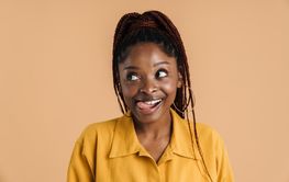 Young black woman with afro pigtails showing her tongue...