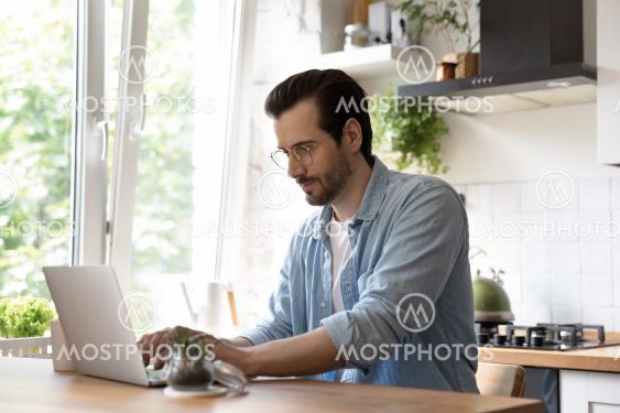 Millennial man look at laptop screen working online