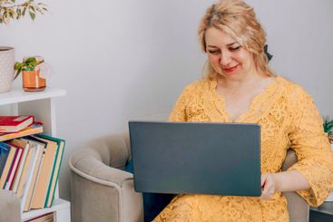 businesswoman working on laptop in home office, relaxed...