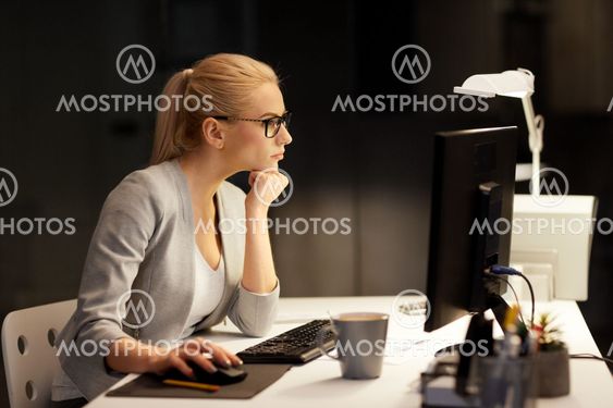 businesswoman at computer working at night office