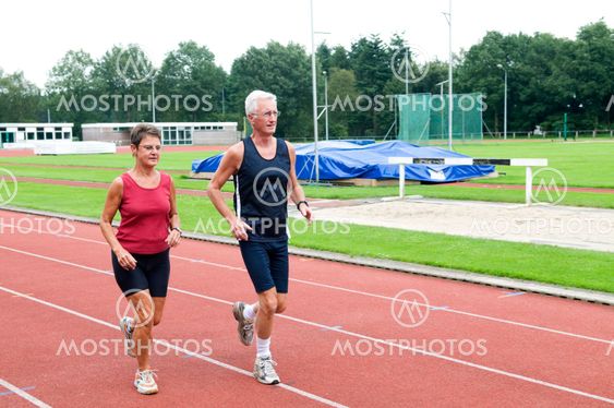 Senior Couple Running On A Track