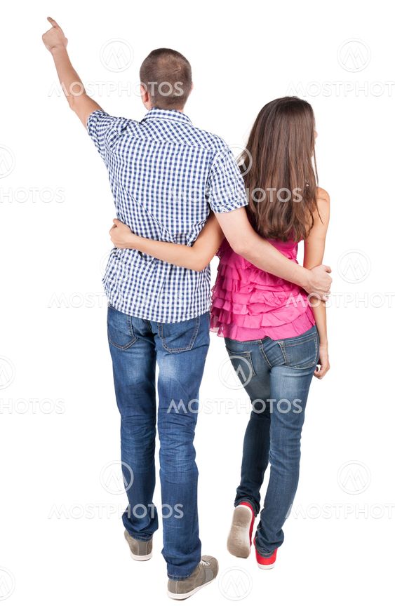 young couple pointing at wal Back view
