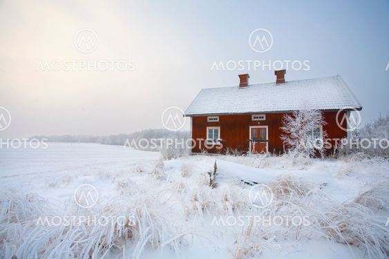 Röd stuga i vinterlandskap