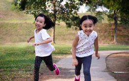 Asian Little Chinese Sisters running happily