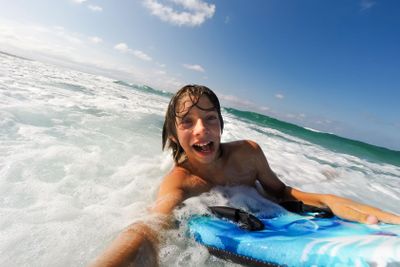  boy enjoys riding the waves with a surfboard