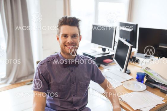 happy creative male office worker with computers