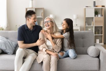 Caring young adult son small granddaughter embrace...