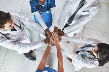 Doctor, meeting and hands together with teamwork above...