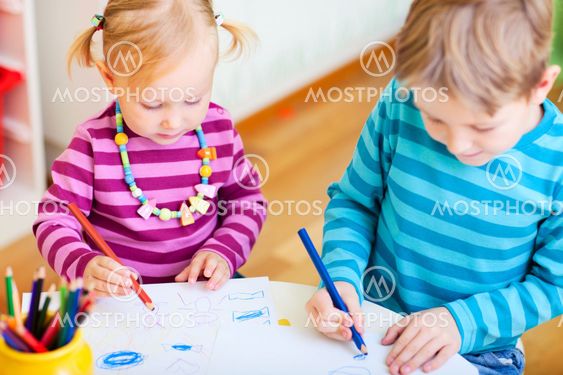 Brother and sister drawing in their room