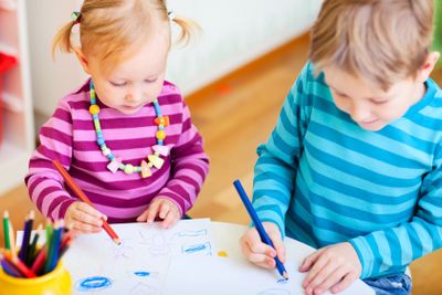 Brother and sister drawing in their room