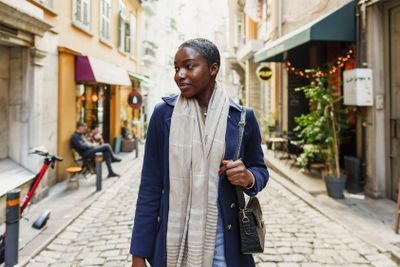 Young african woman walks alone on europe street