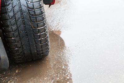 view of vehicle tire on wet road