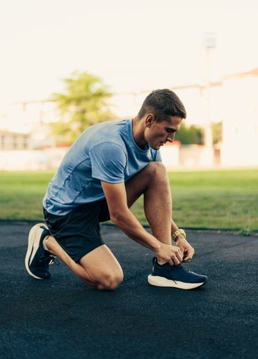 Athlete preparing for a training session by tying...