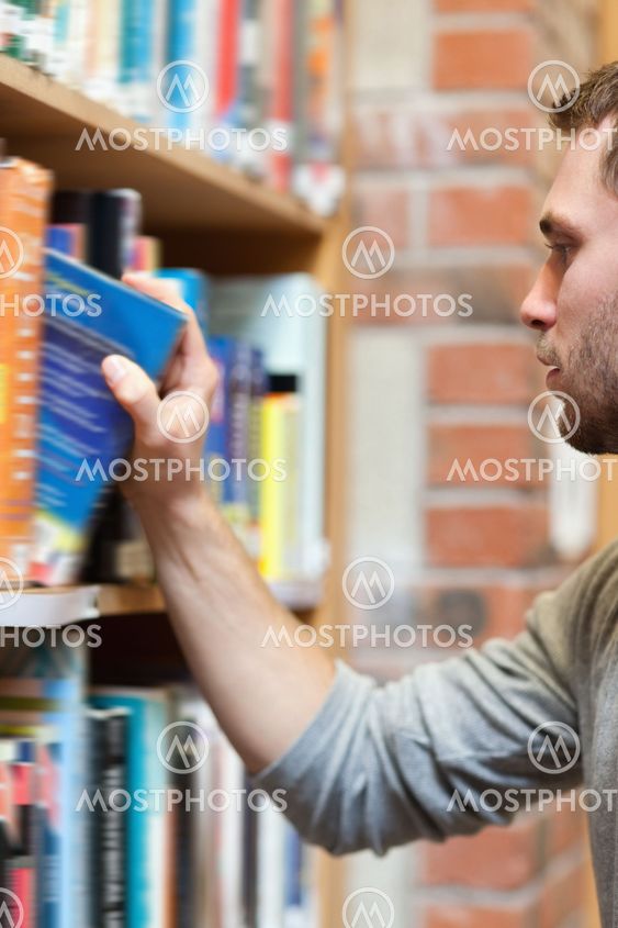 Portrait of a male student picking a book
