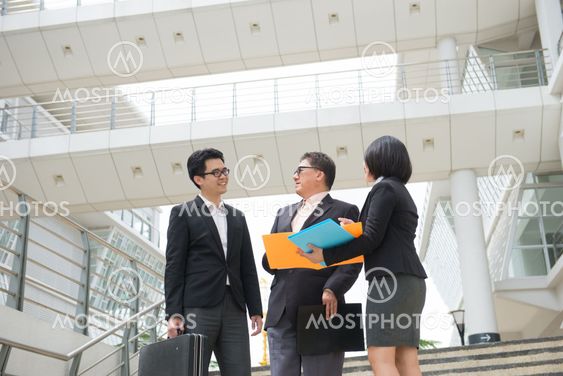 asian business team reporting to senior ceo with office background