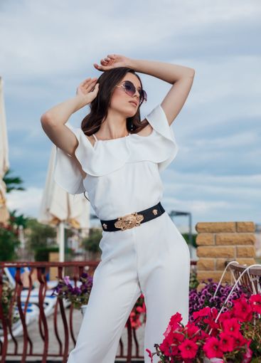 Beautiful brunette woman in white suit posing on the...