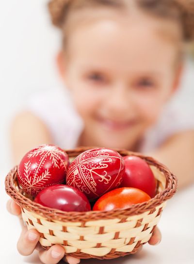 Happy girl holding easter eggs in a basket