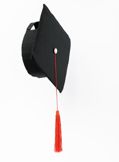 Graduation cap with red tassel isolated on white
