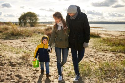 happy family walking along autumn beach