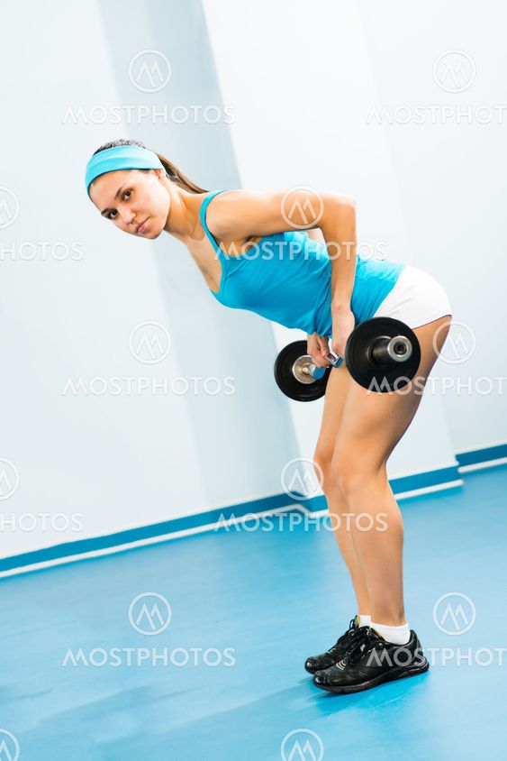 young woman doing body-building in the Gym
