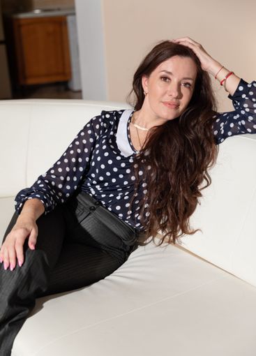 Beautiful brunette woman sitting on a white sofa at home