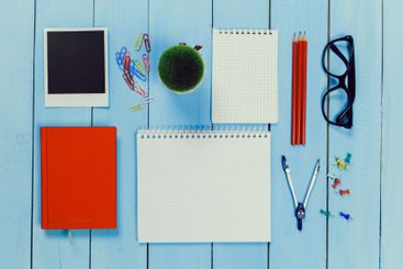 Workspace arrangement with colorful stationery items on...