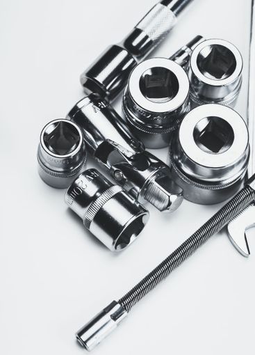 Collection of various metallic tools arranged on a flat...