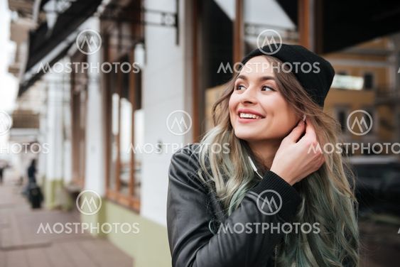 Gorgeous young woman wearing hat walking on the street