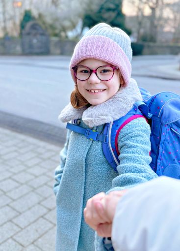 Cute little girl o the way to or from school. Healthy...