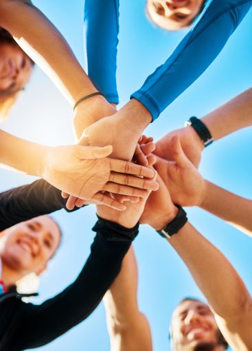 Happy group, below and huddle with hands together for...