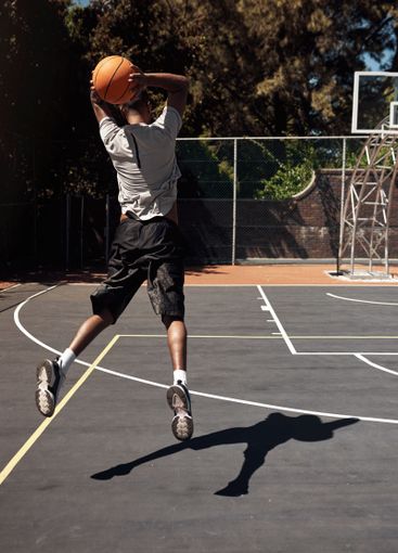 Man, basketball player and jumping with ball in court...