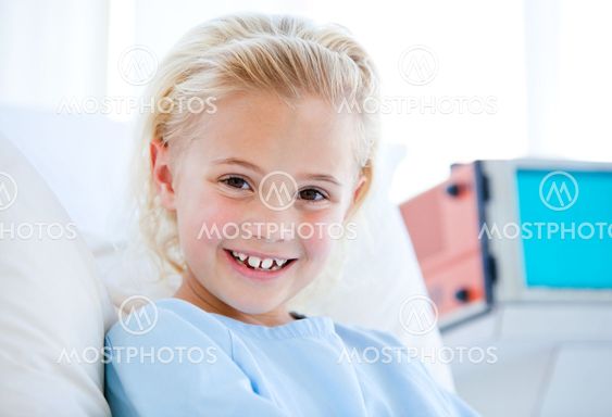 Sick little girl sitting on a hospital bed
