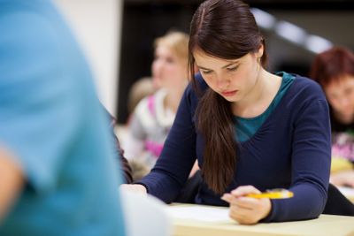 pretty, female college student sitting in a classroom...