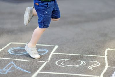 Child playing hopscotch game on playground outdoors on a...