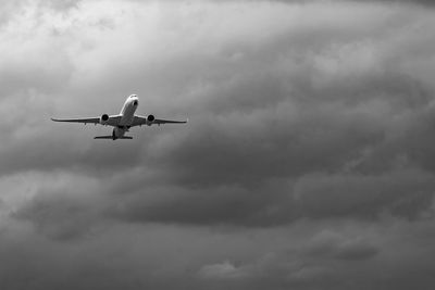 Commercial airplane on grey sky and clouds with copy...