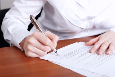 person's hand signing document