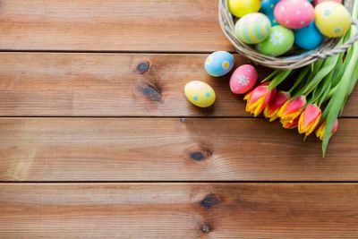 close up of easter eggs in basket and flowers