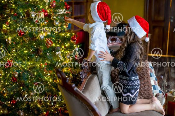 Boy and girl decorate the Christmas tree