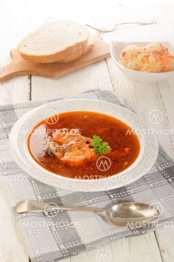 hungarian fish soup in a soup plate, salad and bread