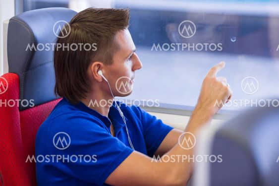 Young caucasian man listening music look at window...